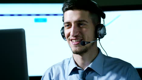 A-young-man,who-work-in-customer-service-or-in-some-airport-control-tower-station,-answers-calls-to-phone-customers-with-a-smile-day-and-night.