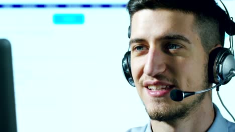 Un-hombre-joven,-que-trabaja-en-servicio-al-cliente-o-en-alguna-estación-de-torre-de-control-del-aeropuerto,-responde-a-las-llamadas-a-los-clientes-de-teléfono-con-una-sonrisa-día-y-noche.