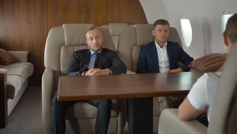 Businesspeople-discussing-inside-business-private-jet