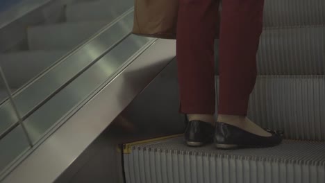 Girl-on-the-escalator.-Phone-sticking-out-of-the-bag.