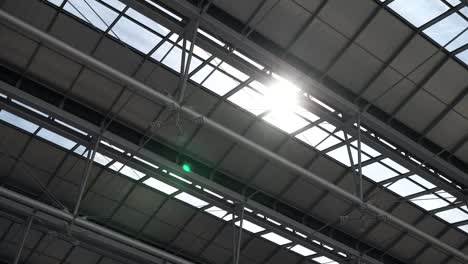 Shiny-sun-light-passing-through-the-building-roof-and-glass-ceiling,-creating-sunlight-flare