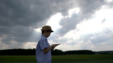 chico-disfruta-de-vistas-de-la-naturaleza-y-utiliza-tablet,-soñador-y-artista