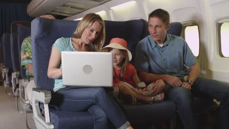 Family-using-laptop-on-plane