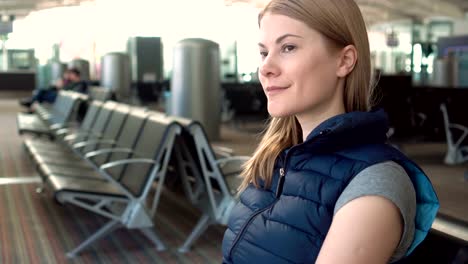 Beautiful-attractive-young-woman-at-the-airport.-Waiting-for-her-flight.-Looking-around.-Thinking