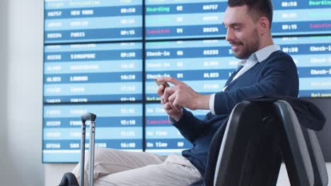 Man-using-Phone-while-Waiting-Boarding-at-Departure-Lounge-at-the-Airport.