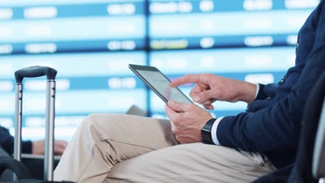 Mann-mit-Tablet-beim-Boarding-warten-am-Abflug-Lounge-am-Flughafen.