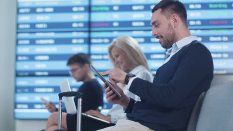 Mann-mit-Tablet-beim-Boarding-warten-am-Abflug-Lounge-am-Flughafen.