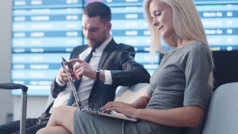 Business-Frau-mittels-Laptop-beim-Warten-Boarding-am-Abflug-Lounge-am-Flughafen.