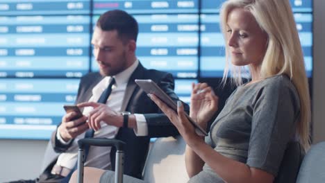 Business-Woman-Using-Tablet-Computer-while-Waiting-Boarding-at-Departure-Lounge-at-the-Airport.