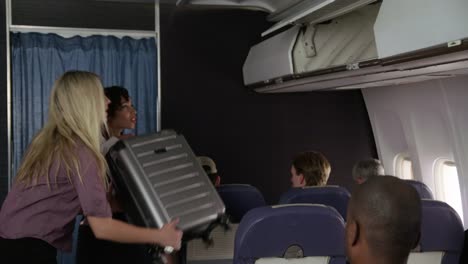 Flight-attendant-helping-passenger-with-luggage