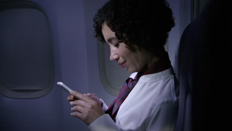 Auxiliar-de-vuelo-utilizando-el-teléfono-celular-en-la-noche