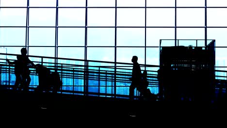 Sonnenuntergang-Silhouetten-der-Pendler-im-Flughafen.