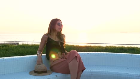 Portrait-of-young-attractive-woman-in-sunglasses-at-seafront