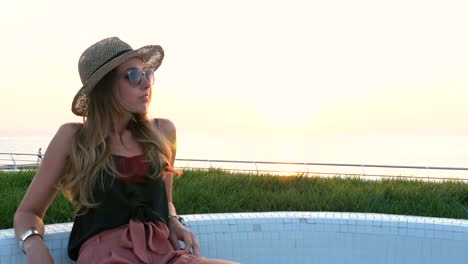 Portrait-of-young-attractive-woman-in-sunglasses-at-seafront