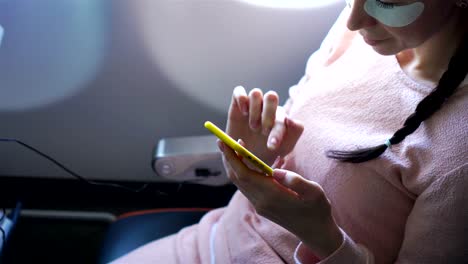 Joven-mujer-feliz-viajando-en-un-avión.-Lindo-niño-con-ordenador-portátil-junto-a-la-ventana-en-el-avión