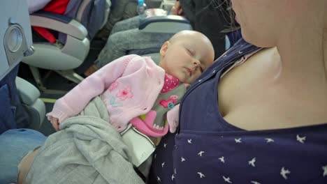 A-Woman-Holding-her-Child-on-a-Plane