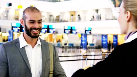 Businessman-showing-his-boarding-pass-at-the-check-in-counter