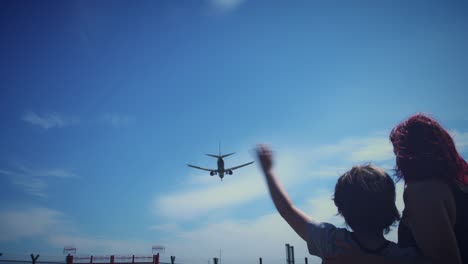 4k-Dublin-Airport,-Child-with-Mom-Waving-at-Airplane