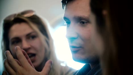 Group-of-young-people-flying-on-the-plane-together.-Happy-friends,-man-and-woman-talking,-going-to-the-trip