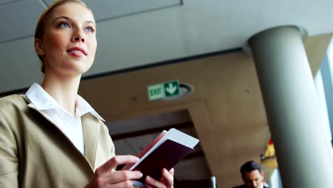 Woman-holding-passport-and-air-ticket-at-airport