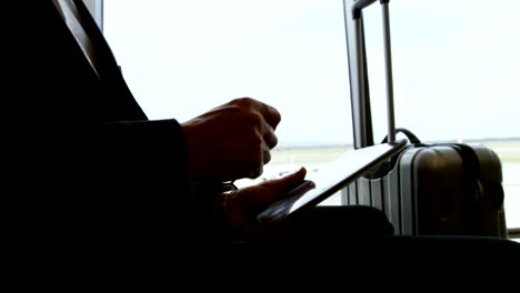 Businessman-using-digital-tablet-at-airport