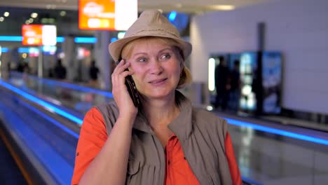 Una-mujer-en-el-aeropuerto-y-hablar-por-teléfono.