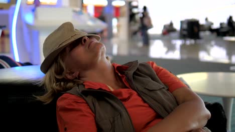 Mujer-durmiendo-en-el-aeropuerto-en-el-sofá.