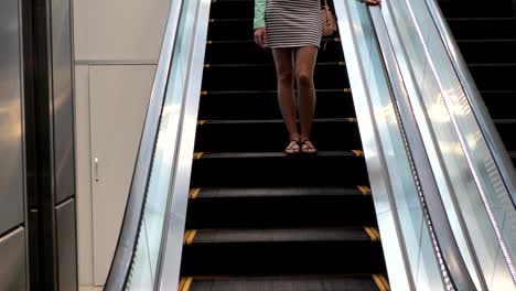 Pretty-Young-Brunette-Woman-Coming-Down-The-Escalator