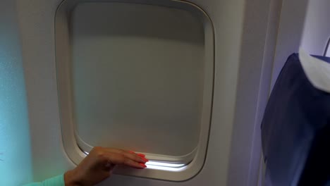 Female-Hand-Close-Up-Opens-And-Closes-The-Shutter-Of-The-Window-Of-The-Plane