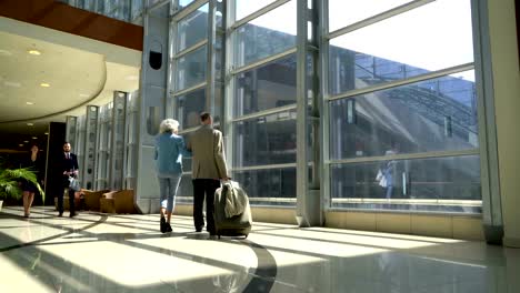 Two-seniors-walking-with-suitcase