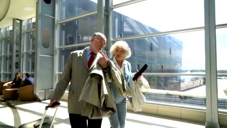 Two-seniors-walking-with-suitcase