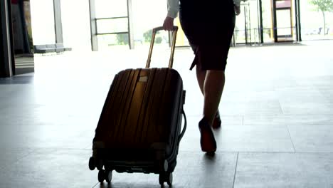 Business-woman-walking-with-wheeled-bag