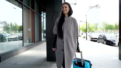 Happy-traveler-smiling-and-carrying-blue-luggage