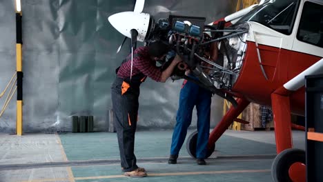 Dos-mecánicos-trabajando-en-un-avión-pequeño