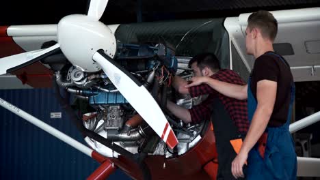 Two-mechanics-working-on-a-small-aircraft