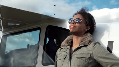 Attractive-woman-pilot-resting-against-her-plane