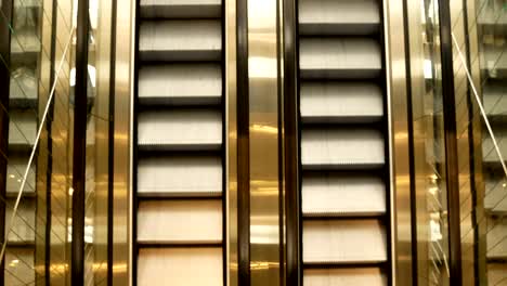 Escalator-in-metro.-Moving-up-staircase.-escalator.-electric-escalator.Close-up-to-escalators.-electric-escalator.Close-up-floor-platform.-yellow-bands.-metal-line-steel.-yellow-gray-steel-line.Moving