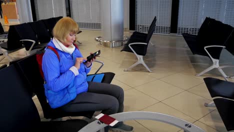 The-woman-at-the-airport-awaiting-departure-and-writes-in-a-smartphone.