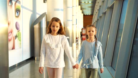 Little-kids-together-in-airport-waiting-for-boarding-near-big-window