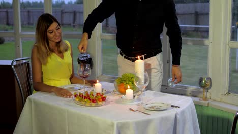 Liebespaar-am-Abend-für-ein-romantisches-Abendessen,-gießt-Man-die-Frau-Rotwein