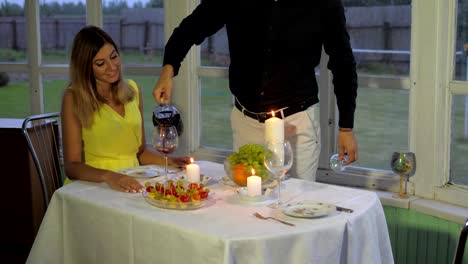 Loving-Couple-In-The-Evening-For-A-Romantic-Dinner,-Man-Pours-The-Woman-Red-Wine