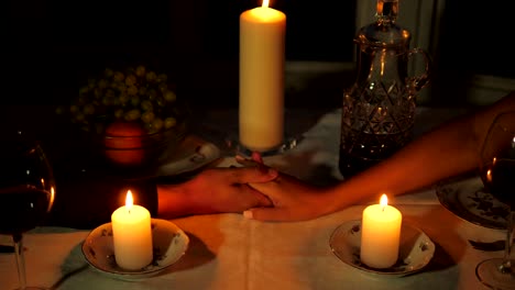 Close-up-Of-Man's-Hand-Takes-The-Woman's-Hand-Over-The-Table-Candles