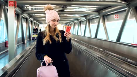 Mujer-joven-con-smartphone-en-aeropuerto