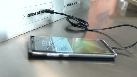 Traveler-charging-mobile-phone-battery-at-free-service-charging-station-at-International-Airport.