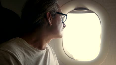 man-looking-out-of-airplane-window