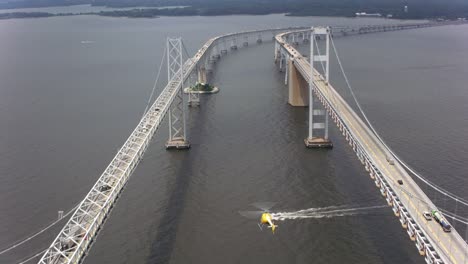 Aerial-shot-of-helicopter-flying-by-the-Chesapeake-Bay-Bridge.