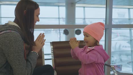 Jungen-Mutter-und-kleine-niedliche-Tochter,-die-Spaß-am-Flughafen-in-Zeitlupe.