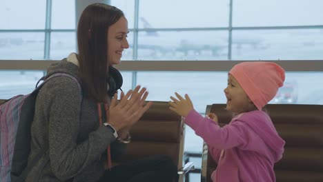 Jungen-Mutter-und-kleine-niedliche-Tochter,-die-Spaß-am-Flughafen-in-Zeitlupe.