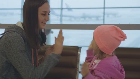 Jungen-Mutter-und-kleine-niedliche-Tochter,-die-Spaß-am-Flughafen-in-Zeitlupe.