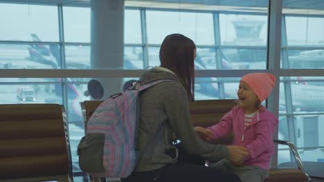 Jungen-Mutter-und-kleine-niedliche-Tochter,-die-Spaß-am-Flughafen-in-Zeitlupe.